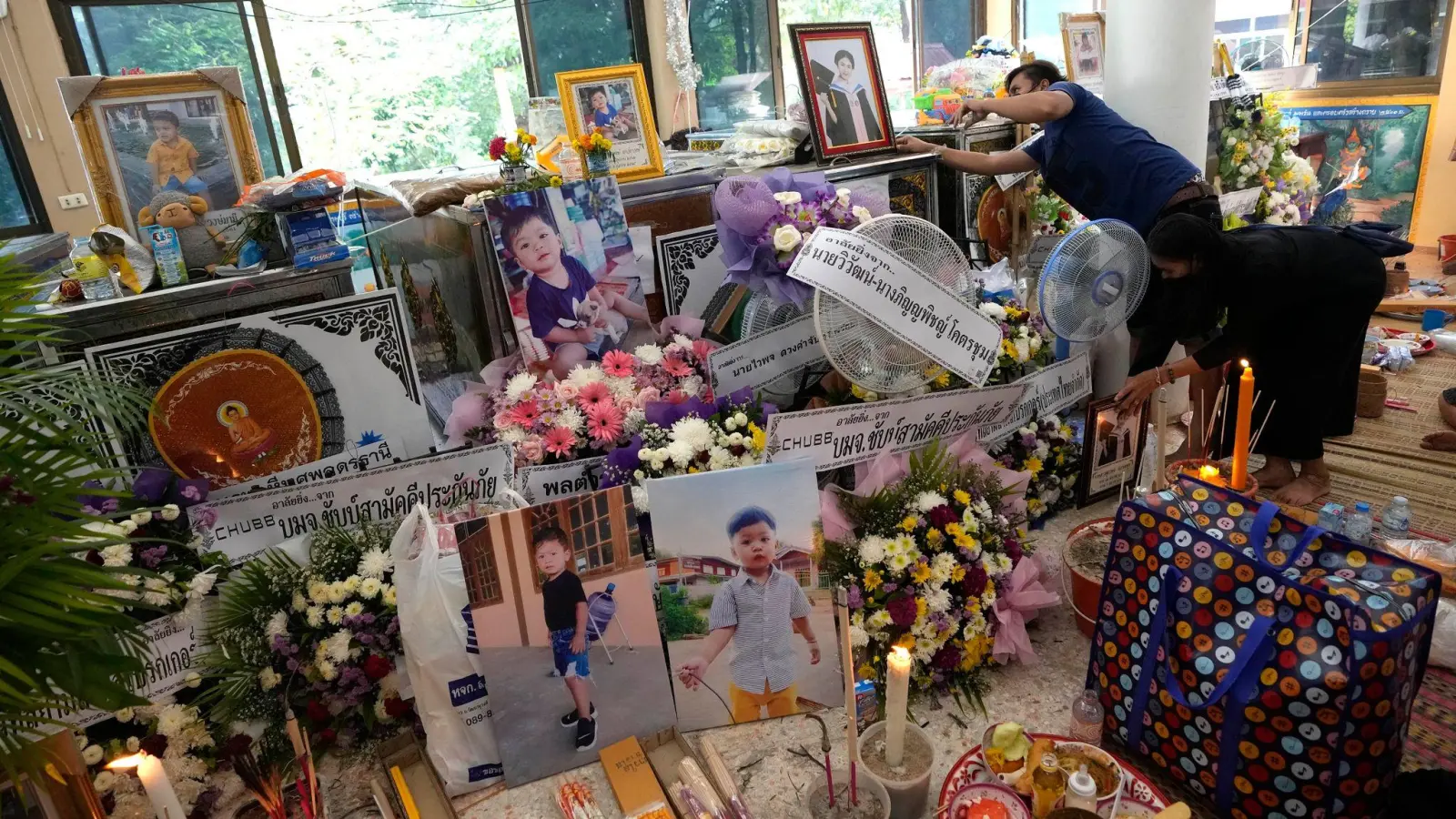 Angehörige der Opfer des Kita-Attentats sammeln Bilder und Andenken vor einer buddhistischen Zeremonie in der Stadt Uthai Sawan im Nordosten Thailands. (Foto: Sakchai Lalit/AP/dpa)