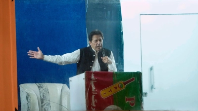 Geschützt durch eine kugelsichere Barriere spricht Imran Khan bei einer Kundgebung in Lahore. Pakistans Ex-Premierminister ist wegen Ermittlungen in einem Korruptionsverfahren in Islamabad verhaftet worden. (Foto: K.M. Chaudary/AP/dpa)