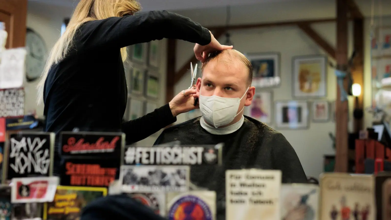 Andrea Siepert-Fichter frisiert ihrem Kunden Benjamin Hartwig in ihrem Salon im Prenzlauer Berg die Haare. Der Salon bietet „Silent Cuts“ an. (Foto: Carsten Koall/dpa)