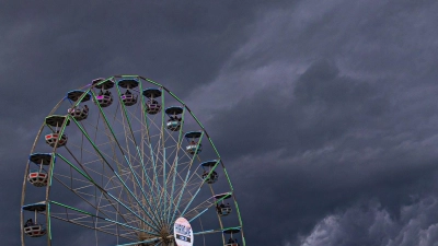 Dunkle Regenwolken ziehen über ein Riesenrad auf dem Gelände des Hurricane-Festivals in Scheeßel hinweg. (Foto: Moritz Frankenberg/dpa)