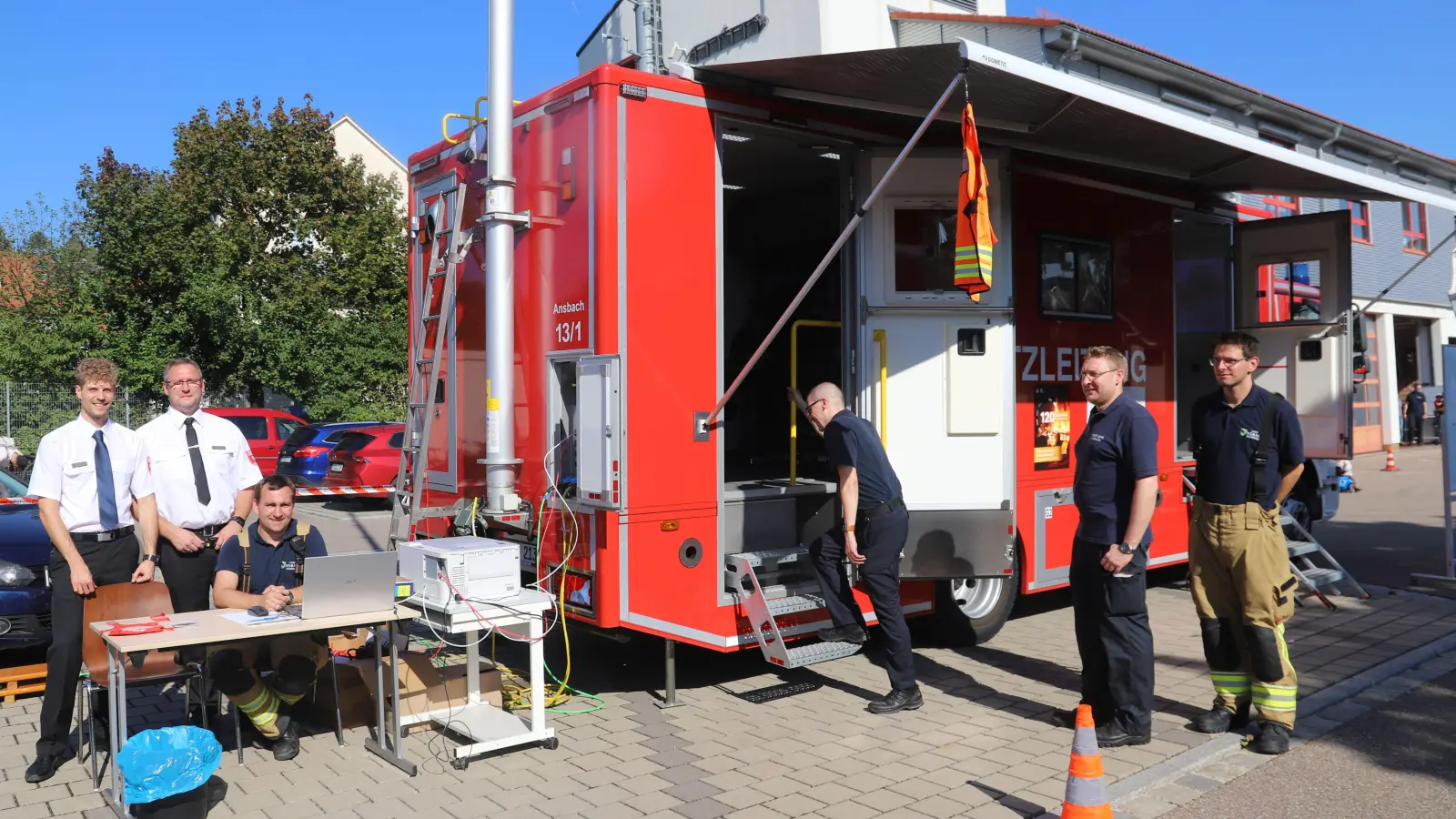 Stadtbrandrat Steffen Beck (Zweiter von links) und Stadtbrandinspektor Pascal Mittemeyer (links) sehen sich bei der Unterstützungsgruppe Örtlicher Einsatzleiter (UG ÖEL) der Freiwilligen Feuerwehr um. Hier waren vor Ort (von links): Simon Bachbauer, Michael Brand, Leiter Jens Ziegler und Jan Bernhard. (Foto: Oliver Herbst)