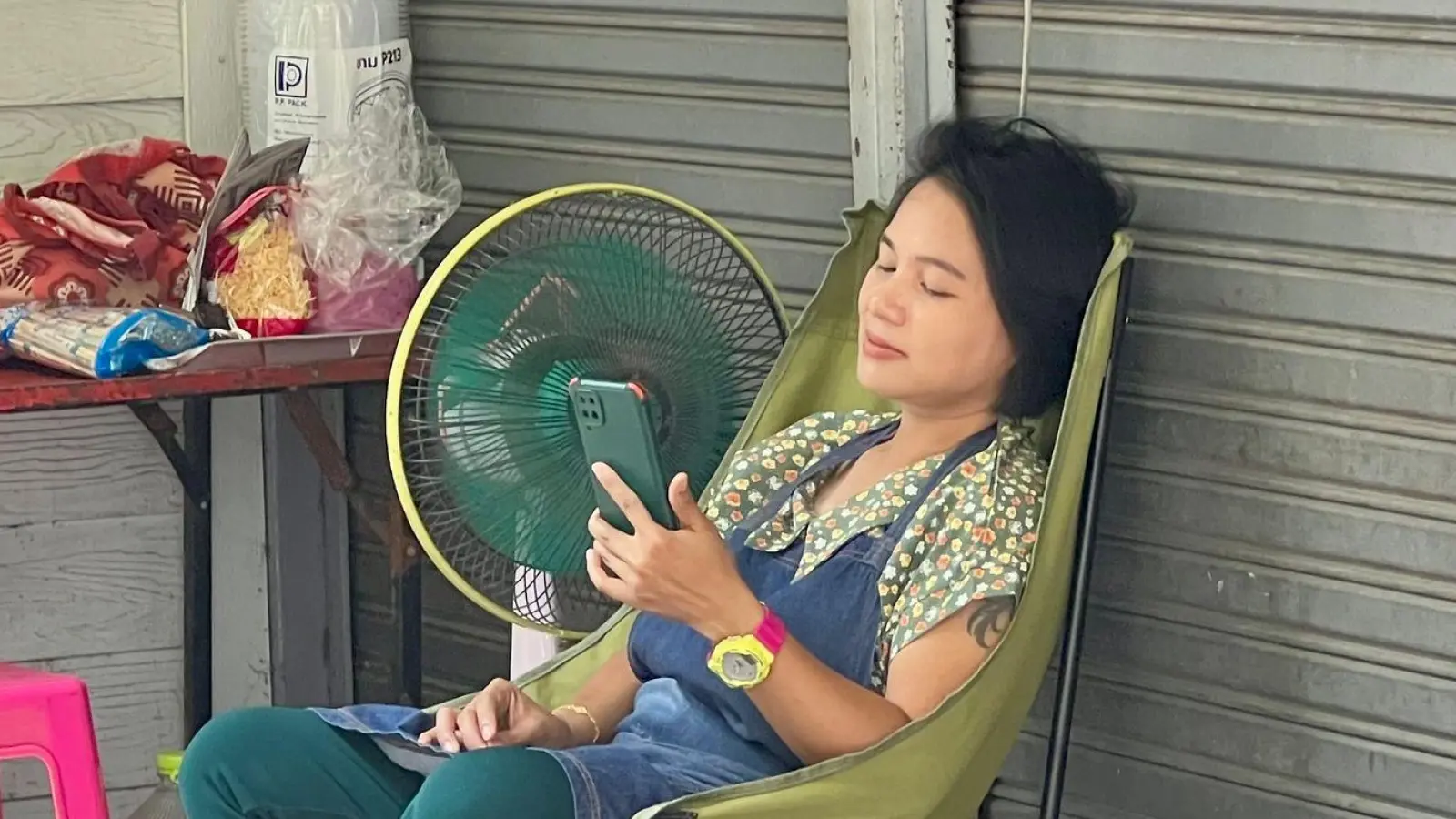 Im Schatten und mit Ventilator: Eine Frau in Bangkok versucht, sich sich abzukühlen. (Foto: Carola Frentzen/dpa)