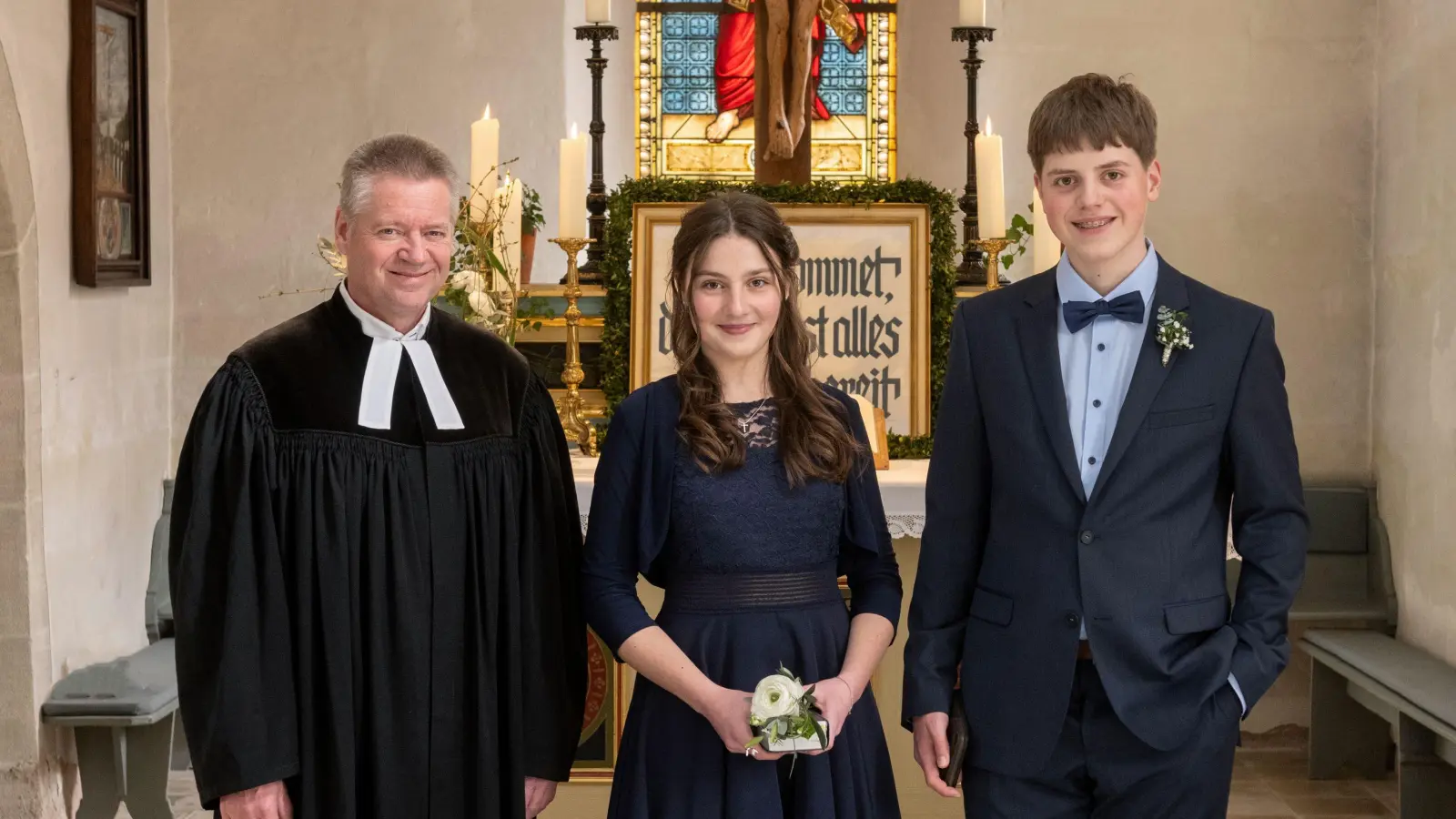 Pfarrer Stephan Rühr mit der Konfirmandin und dem Konfirmanden vor dem Altar in der St.-Michael-Kirche zu Lentersheim. (Foto: Beate Kißlinger)