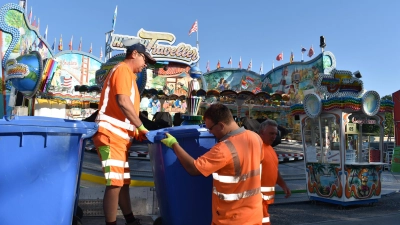 Sie sind ein gut eingespieltes Team Jörg Deyerling (links), Fabian Schmidt und Konrad Hecht (rechts). Sie sammeln die rund 50 exakt 240 Liter fassenden Mülltonnen ein, verladen sie und bringen sie zur Wertstoffsammelstelle am Rand des Festplatzes. Nach dem Entleeren werden die Kübel wieder zurückgebracht. (Foto: Ute Niephaus)