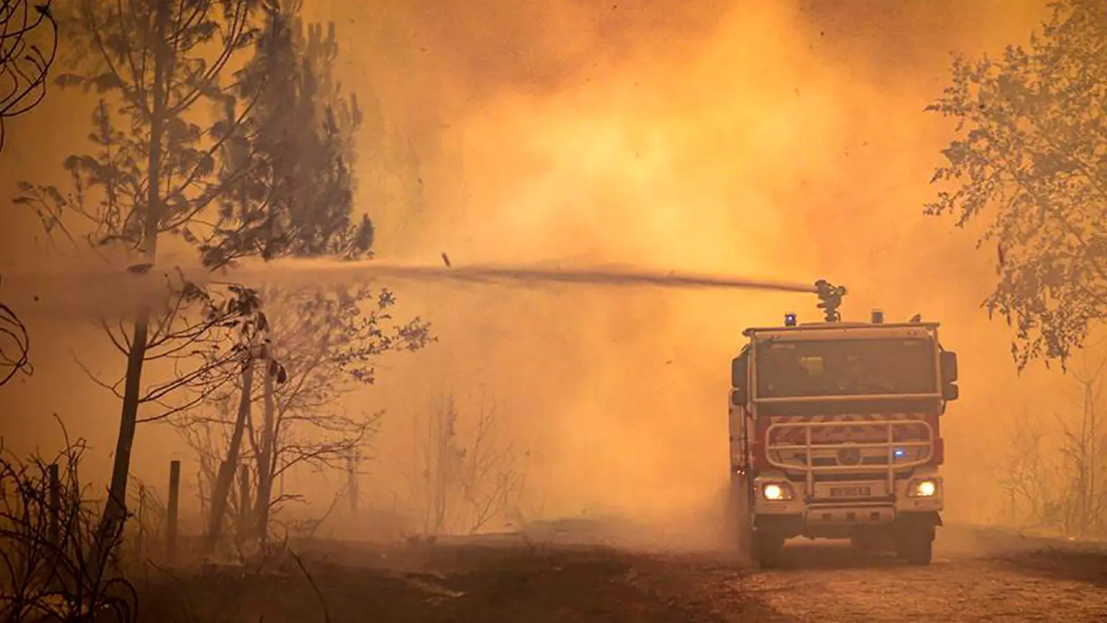 Ein Feuerwehrwagen sprüht Flüssigkeit auf einen Waldbrand in der Region Bordeaux. (Archivbild) (Foto: Uncredited/Service Communication-Protocole SDIS 33/AP/dpa)