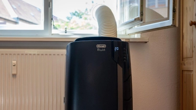Monoblock-Klimagerät mit Abluftschlauch: Wer das Fenster abdichtet – wie hier mit einer Acrylglasscheibe mit Loch – spart Strom und kühlt effizienter. (Foto: Nico Tapia/dpa-tmn)