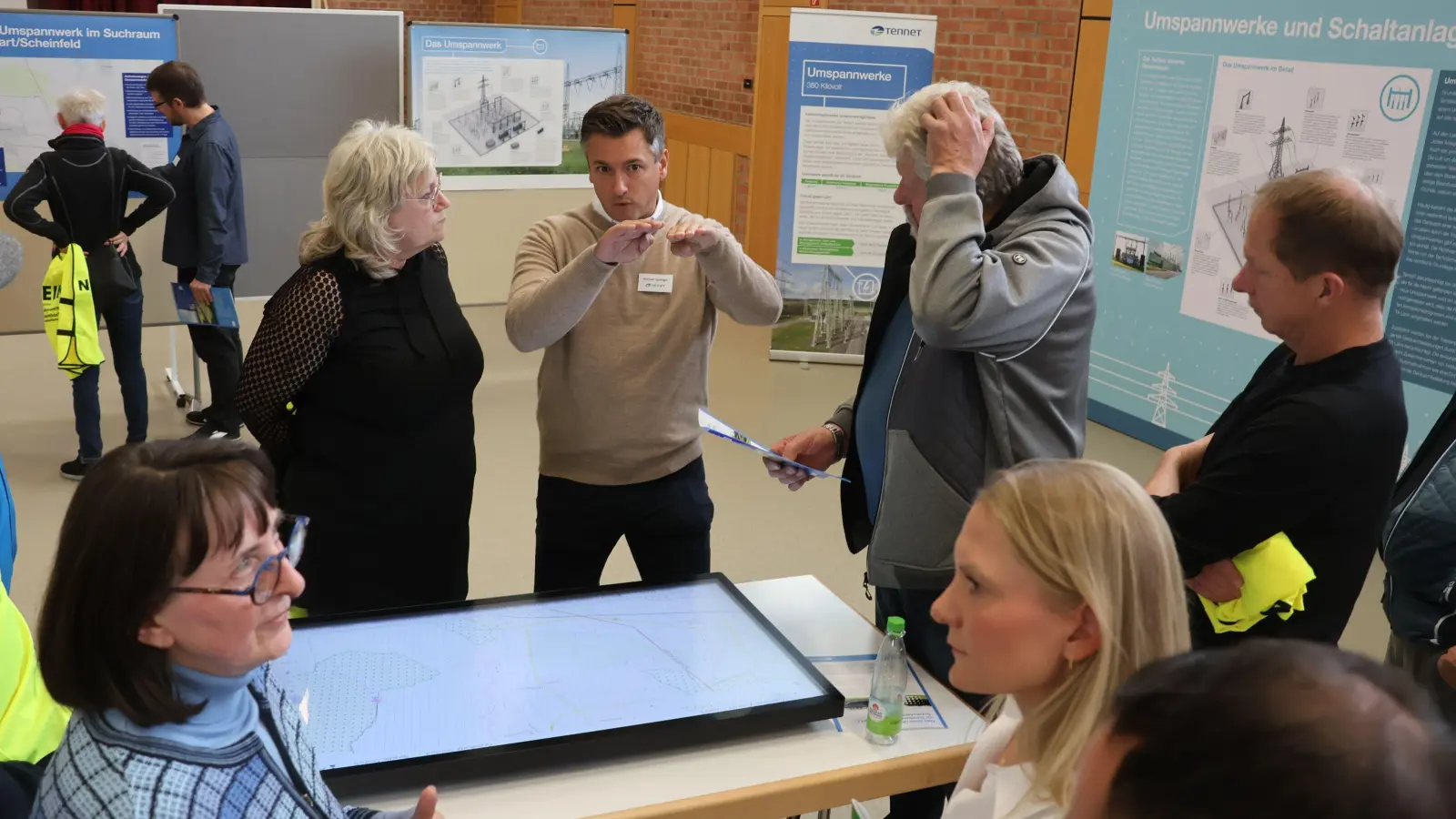 Tennet bot vorigen Herbst in der Scheinfelder Wolfgang-Graf-Halle einen „Informarkt” an. Unter anderem stand unter anderem der Projektverantwortliche Michael Sprenger (Mitte, beiger Pullover) den Bürgerinnen und Bürgern Rede und Antwort. Nun legt der Konzern mit einer Visualisierung auf seiner Homepage in der Informationspolitik nach. (Foto: Andreas Reum)