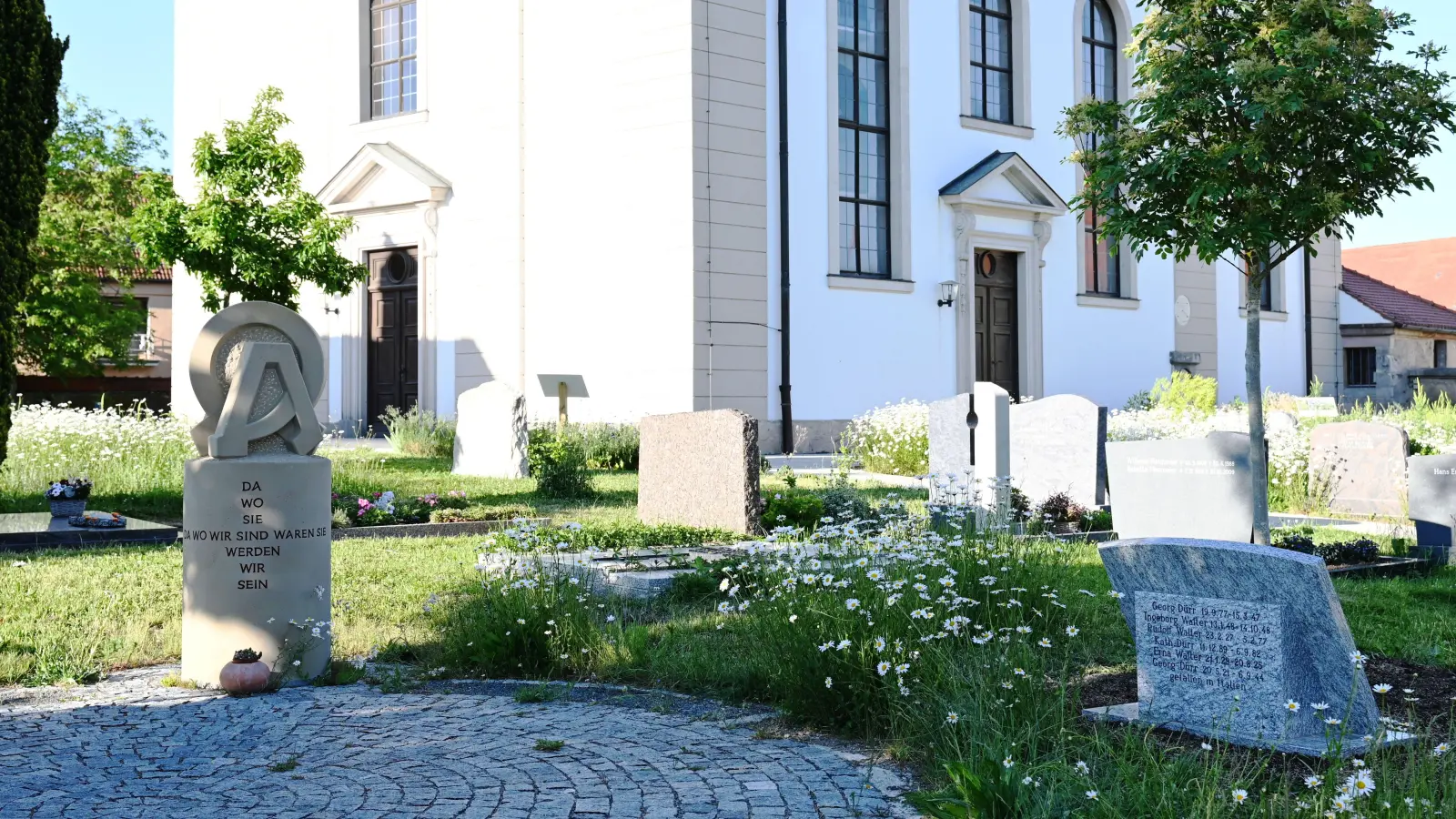 Neu auf dem Friedhof ist auch die Skulptur einer ortsansässigen Künstlerin, die links zu sehen ist. Die Zeichen Omega und Alpha stehen symbolisch für den Anfang und das Ende. (Foto: Luca Paul)
