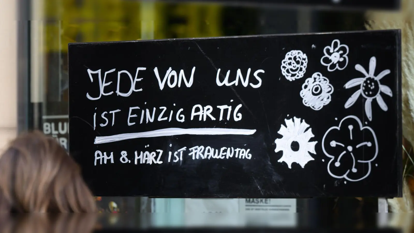 „Jede von ist einzigartig - Am 8. März ist Frauentag“: Ein Schild vor einem Blumenladen in Hannover. (Foto: Julian Stratenschulte/dpa)