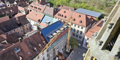 Ein Blick aus der Vogelperspektive: Vom Turm von St. Gumbertus aus ist gut zu erkennen, dass selbst das Dach des geplanten Inklusionshotels noch nicht komplett gedeckt ist. (Foto: Alexander Biernoth)