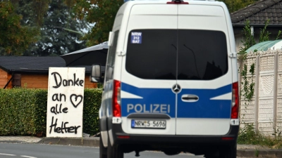 Ein Polizeifahrzeug fährt an einem Schild mit der Aufschrift „Danke an alle Helfer“ vorbei.  (Foto: Federico Gambarini/dpa)