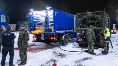 Ein Kraftstoffcontainer vom Technischen Hilfswerk THW wird auf einem Betriebshof vom THW von einem Tankwagen der Bundeswehr getankt.  (Foto: Christophe Gateau/dpa)
