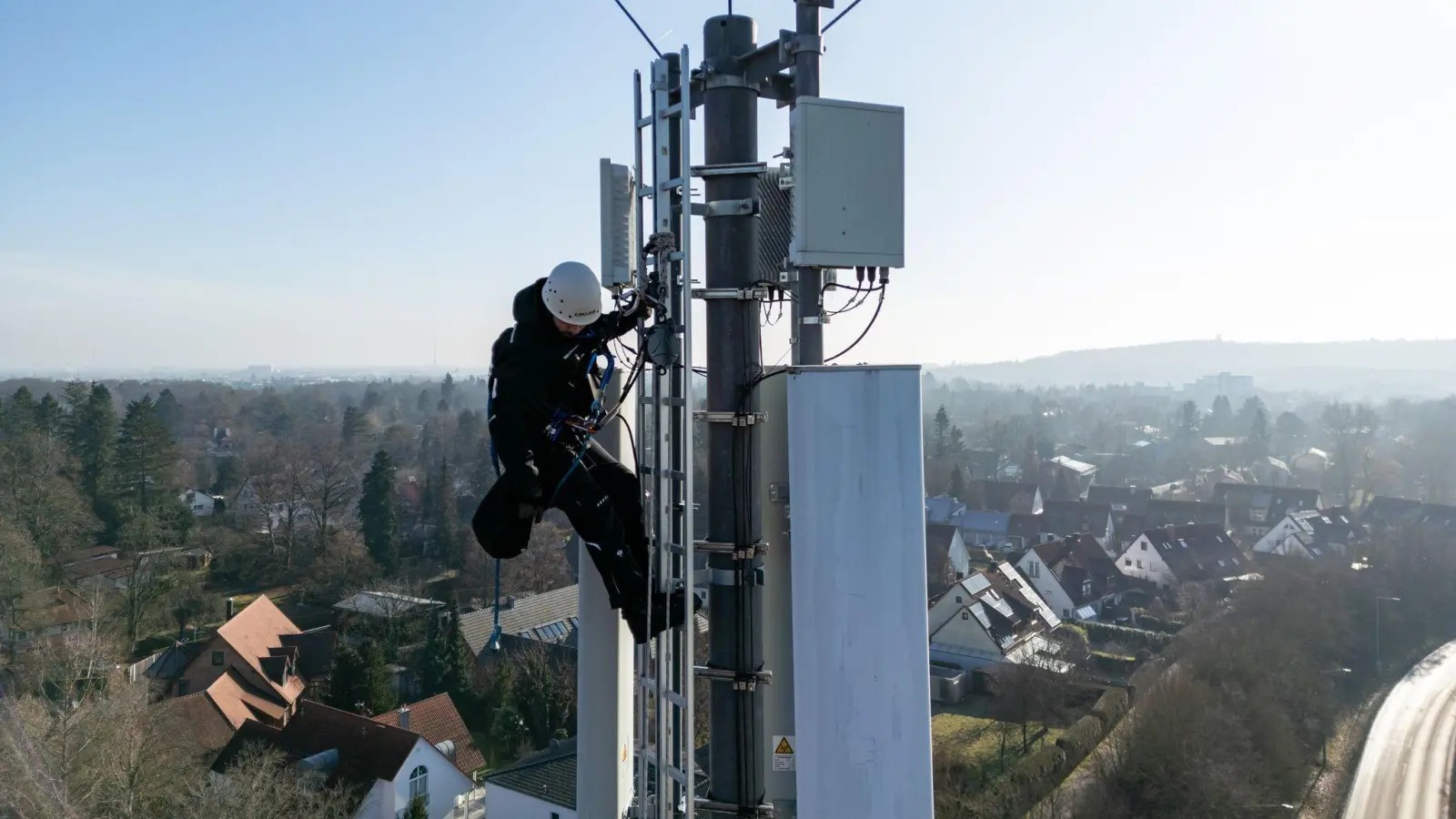 Ein Telekom-Techniker an einem Mobilfunk-Masten - an so einem Standort könnten künftig auch Anti-Drohnen-Sensoren hängen. (Archivbild) (Foto: Daniel Karmann/dpa)