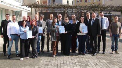 Abgeordnete der teilnehmenden Firmen am fünften UM-Konvoi mit den Initiatoren und IHK-Vertretern sowie Gästen bei der Abschlussveranstaltung in Würzburg: In der vorderen Reihe mit ihren Urkunden die Teams (von links) von Frankana, Freiko, Naturstrom und Alumina Systems. (Foto: Manfred Spörl)