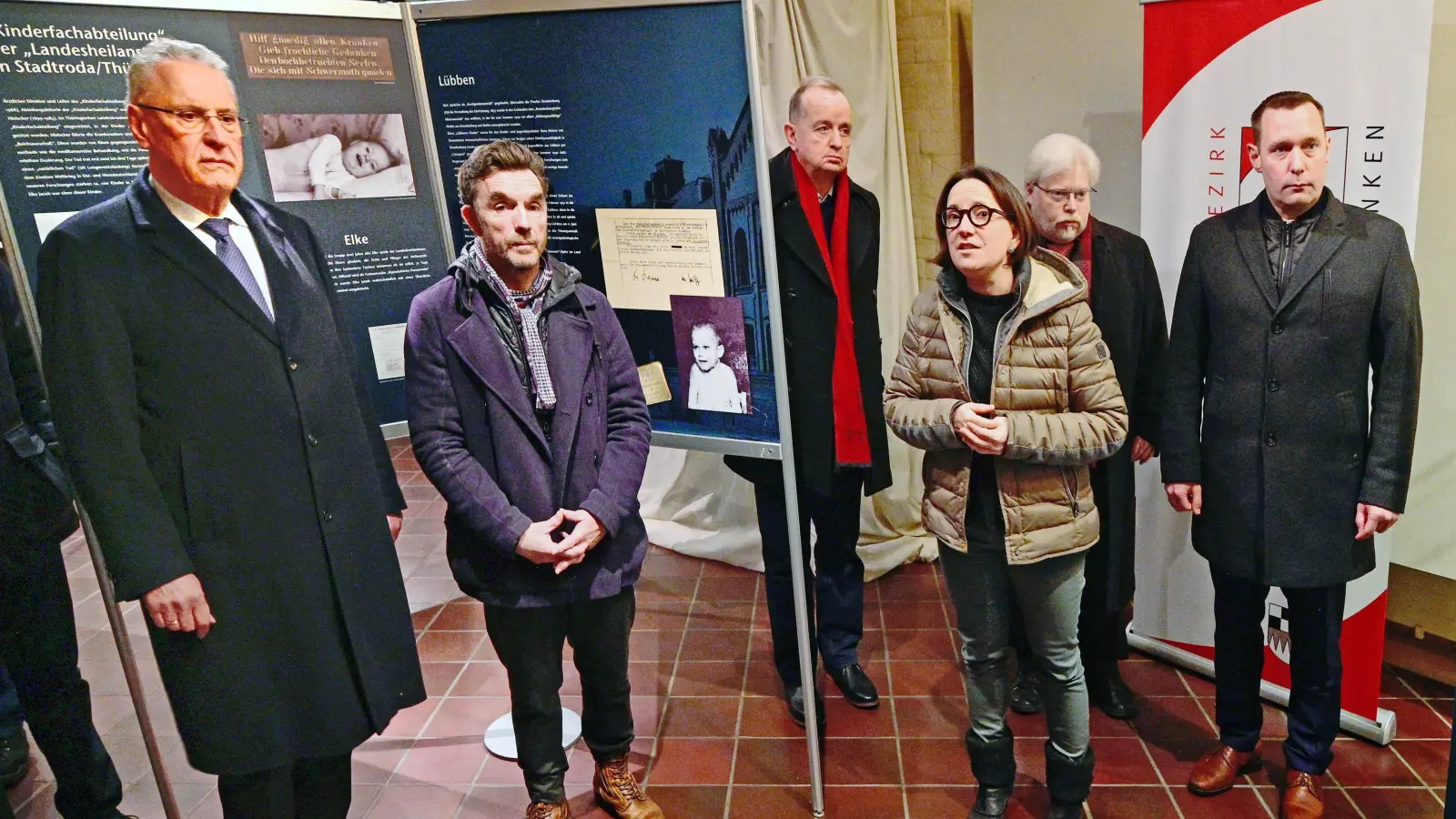 Große Betroffenheit: Innenminister Joachim Herrmann (links), der Ansbacher Oberbürgermeister Thomas Deffner (Dritter von links), der Leiter des Markgrafenmuseums Ansbach, Dr. Wolfgang Reddig (Zweiter von rechts) und Bezirkstagspräsident Armin Kroder (rechts) beim Rundgang durch die Ausstellung Katrin Kasparek und Dr. Mark Deavin (Zweiter von links) eläuterte auch die von ihen ergänzten regionalen Tafeln. (Foto: Jim Albright)