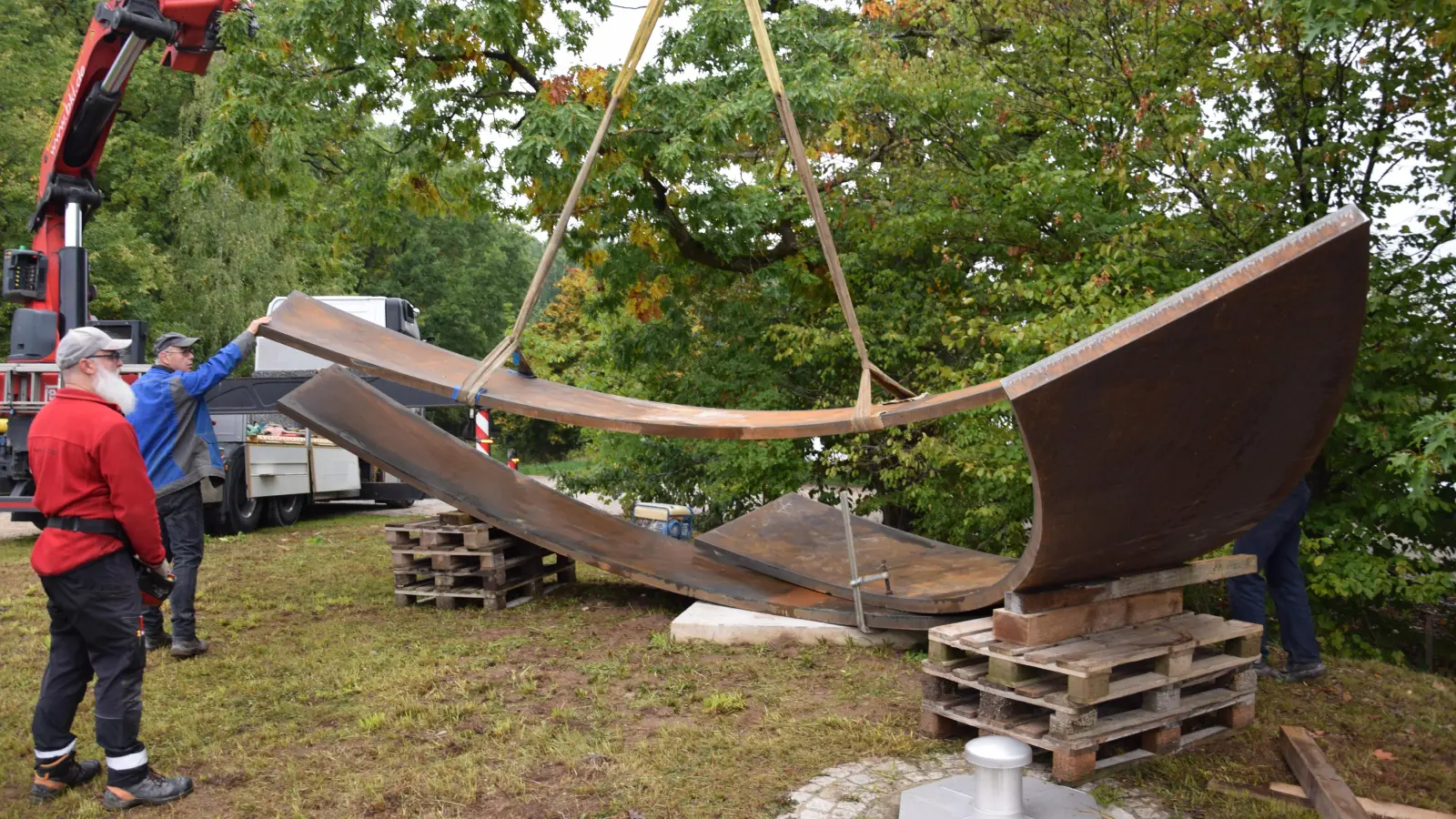 Zentimeterarbeit mit tonnenschweren Teilen. Der Künstler Thomas Röthel (blaue Jacke) legte selbst Hand an, um die drei Elemente seiner Skulptur richtig auszurichten. (Foto: Florian Schwab)