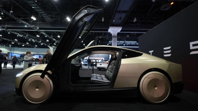 Ein Robotaxi-Fahrzeug ohne Lenkrad und Pedale will Tesla von 2026 an bauen. (Archivbild) (Foto: Jae C. Hong/AP/dpa)