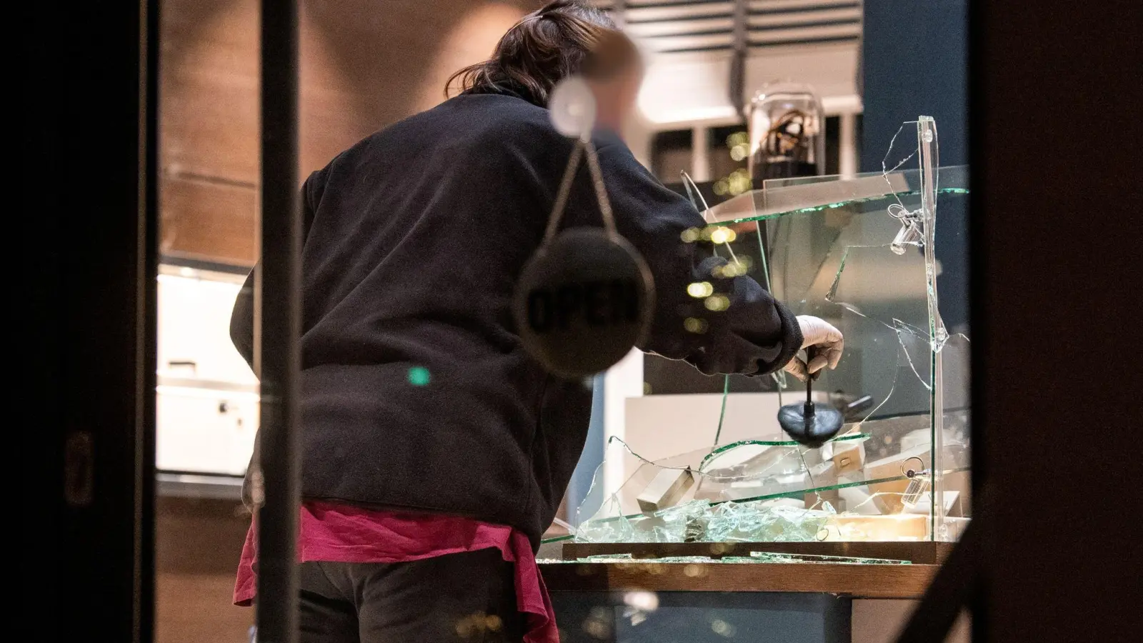 Eine Mitarbeiterin der Spurensicherung untersucht nach dem Überfall eine eingeschlagene Vitrine. (Foto: Daniel Bockwoldt/dpa)