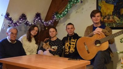 In ihrer Wohnung in der Dinkelsbühler Altstadt haben es sich Andrii Miehuriw (von rechts), Nazar Shmatkov, Katerina Shmatkova und Karyna Potapkina zusammen mit Katze Alfonsina gemütlich gemacht. Vermieter Paul Röseler (links) hilft, wo er kann. (Foto: Philipp Zimmermann)