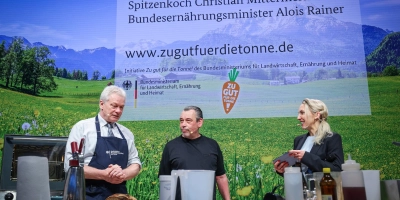 Bundesminister Alois Rainer (links) und Christian Mittermeier beim gemeinsamen Kochen. Mit im Bild ist Moderatorin Carolin Kuhn.  (Foto: Ronny Hartmann / BMLEH)