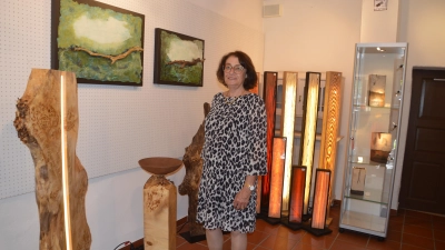 Die Leiterin der Kleinen Galerie, Monika Hofecker, vor den Objekten der Holz- und Lichtkunst von Steffen Hufnagl (Foto: Peter Tippl)