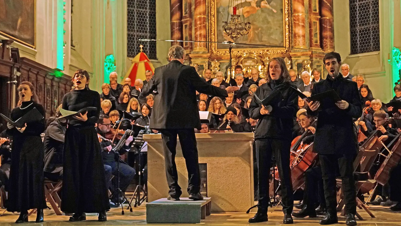 Ein Konzert für Ohren – und Augen: der Altarraum der Stiftsbasilika Herrieden war für die Aufführung des Gounod-Requiems illuminiert. (Foto: Elke Walter)