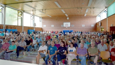 Das Interesse der Petersauracher war groß: Obwohl neben den Stuhlreihen noch Bänke aufgestellt wurden, mussten zahlreiche Bürger stehen oder auf dem Boden in der Turnhalle Platz nehmen. (Foto: Florian Schwab)