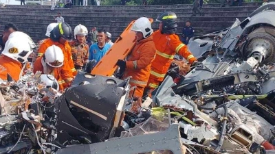 Rettungsdienst und Feuerwehr inspizieren die Absturzstelle. (Foto: Terence Tan/Fire & Rescue Department of Malaysia/AP/dpa)