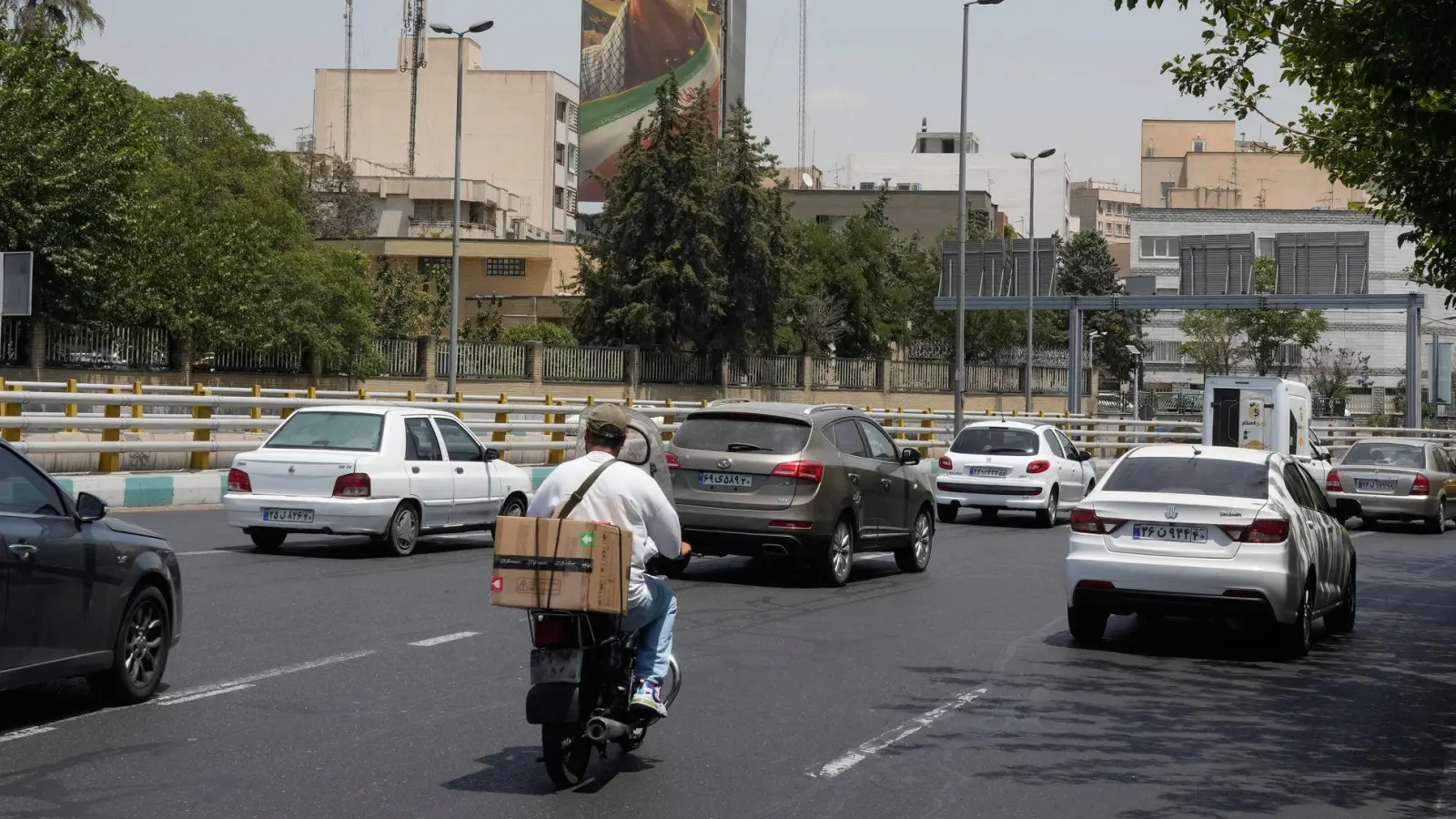 Fahrzeuge fahren in Teheran an einer Plakatwand vorbei, auf der die geballte Faust des verstorbenen iranischen Obersten Führers Ajatollah Ali Chamenei zu sehen ist. (Archivbild) (Foto: Vahid Salemi/AP/dpa)