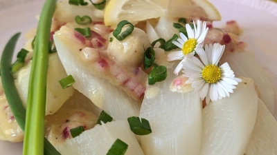 Rote Zwiebelwürfelchen und Gänseblümchen verpassen dem Spargelsalat mit erfrischender Zitrusnote ein paar frühsommerliche Farbtupfer. (Foto: Doreen Hassek/hauptstadtkueche.blogspot.com/dpa)