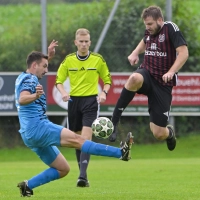 Wenn das mal nicht einem der beiden Spiele weh tut: Tom Wassermann von der SG Mosbach-Breitenau spritzt gegen Alexander Häßlein vom FC Dombühl dazwischen. Schiedsrichter Simon Dimmerling schaut genau hin. (Foto: Martin Rügner)