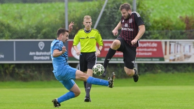 Wenn das mal nicht einem der beiden Spiele weh tut: Tom Wassermann von der SG Mosbach-Breitenau spritzt gegen Alexander Häßlein vom FC Dombühl dazwischen. Schiedsrichter Simon Dimmerling schaut genau hin. (Foto: Martin Rügner)