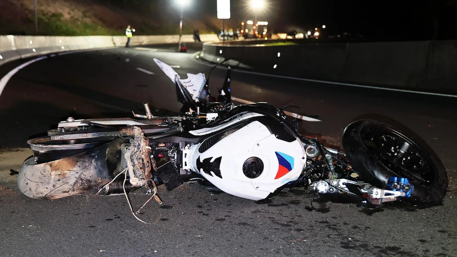 Nach einer Frontalkollision auf der B47 bei Amorbach liegt ein beschädigtes Motorrad auf der Straße. (Foto: Ralf Hettler/dpa)