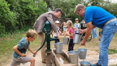 Bezirkstagspräsident Peter Daniel Forster (links) und Rainer Weiskirchen packten beim Befüllen der Eimer kräftig mit an. (Foto: Nina Daebel)