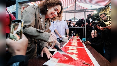 Amsterdams Bürgermeisterin Femke Halsema schneidet die lange Torte an.  (Foto: Ramon Van Flymen/ANP/dpa)