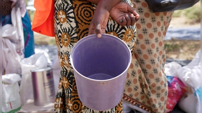 Eine Frau wartet im März 2023 im Bezirk Mangwe im Südwesten Simbabwes auf Nahrungsmittelhilfe. (Foto: Tsvangirayi Mukwazhi/AP/dpa)