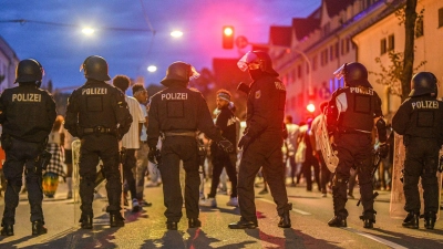 Eine Gruppe von Menschen wird nach Ausschreitungen bei einer Eritrea-Veranstaltung von Polizeikräften eingekesselt. (Foto: Jason Tschepljakow/dpa)