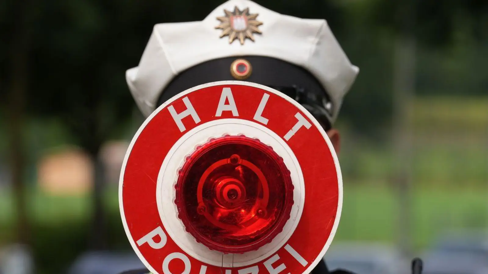 Ein Polizeibeamter hält einen Anhaltestab in einer 30er-Zone während des Blitzermarathons im Stadtteil Wilhelmsburg. (Foto: Marcus Brandt/dpa)