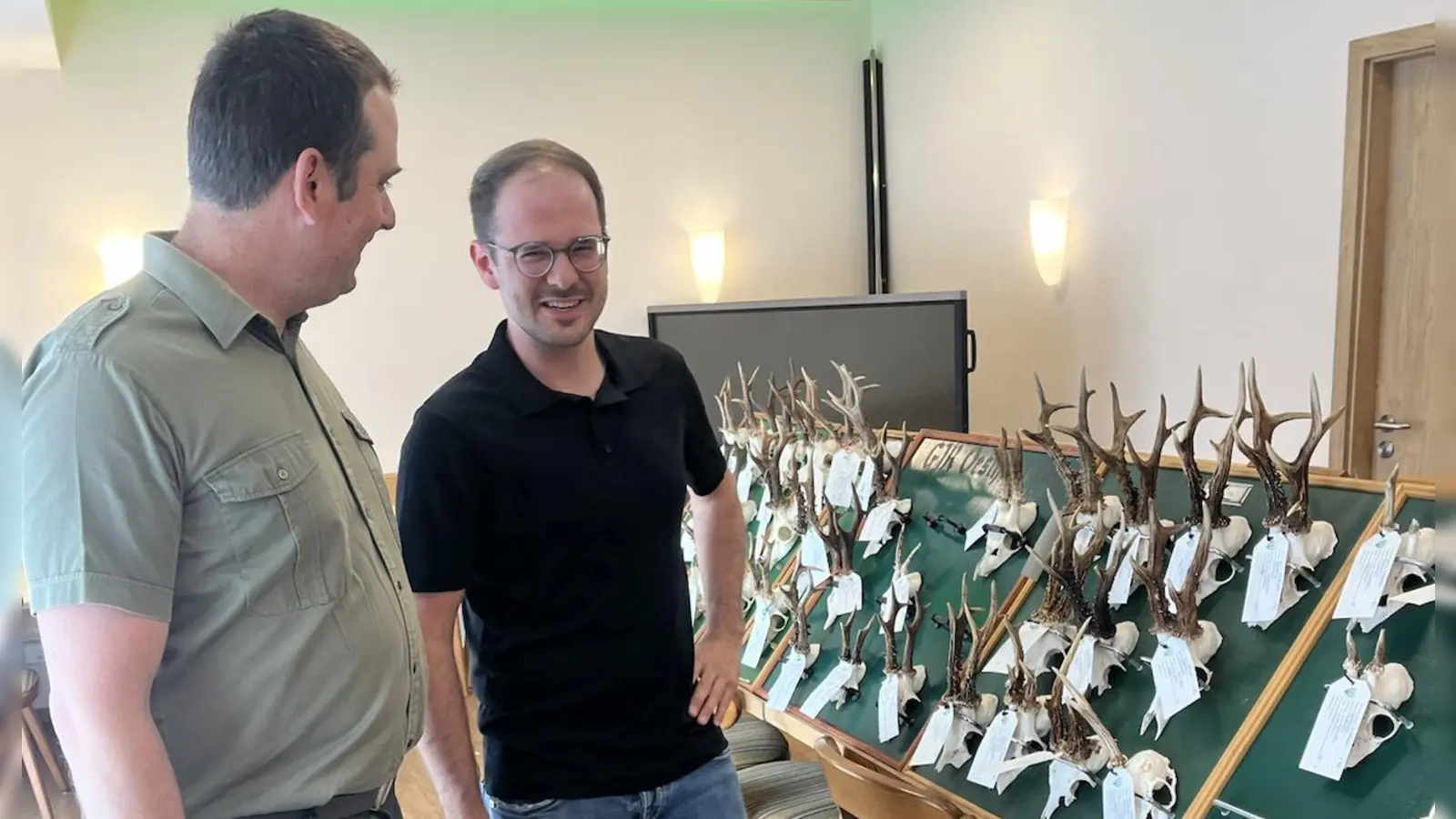 Fester Bestandteil einer Hegeschau und auch gesetzlich festgeschriebene Pflicht ist traditionell die Präsentation der Gehörne. Das Foto zeigt (von links) Gernot Fohrer, den zweiten Vorsitzenden der Jägervereinigung, mit Maximilian Seybold, dem Leiter der Unteren Jagdbehörde, vor den Tafeln. (Foto: Lukas Schneider)