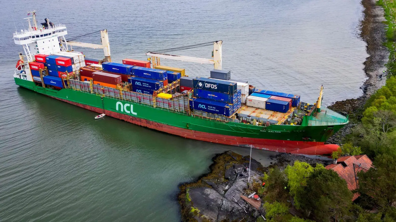 Ein Containerschiff ist in Norwegen kurz vor einem Haus am Wasser zum Stehen gekommen. (Foto: Jan Langhaug/NTB/dpa)