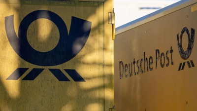 Das gute alte Posthorn, das Logo der Deutschen Post - hier an Lastwagen, die vor einem Kölner Briefzentrum parken. (Foto: Henning Kaiser/dpa)