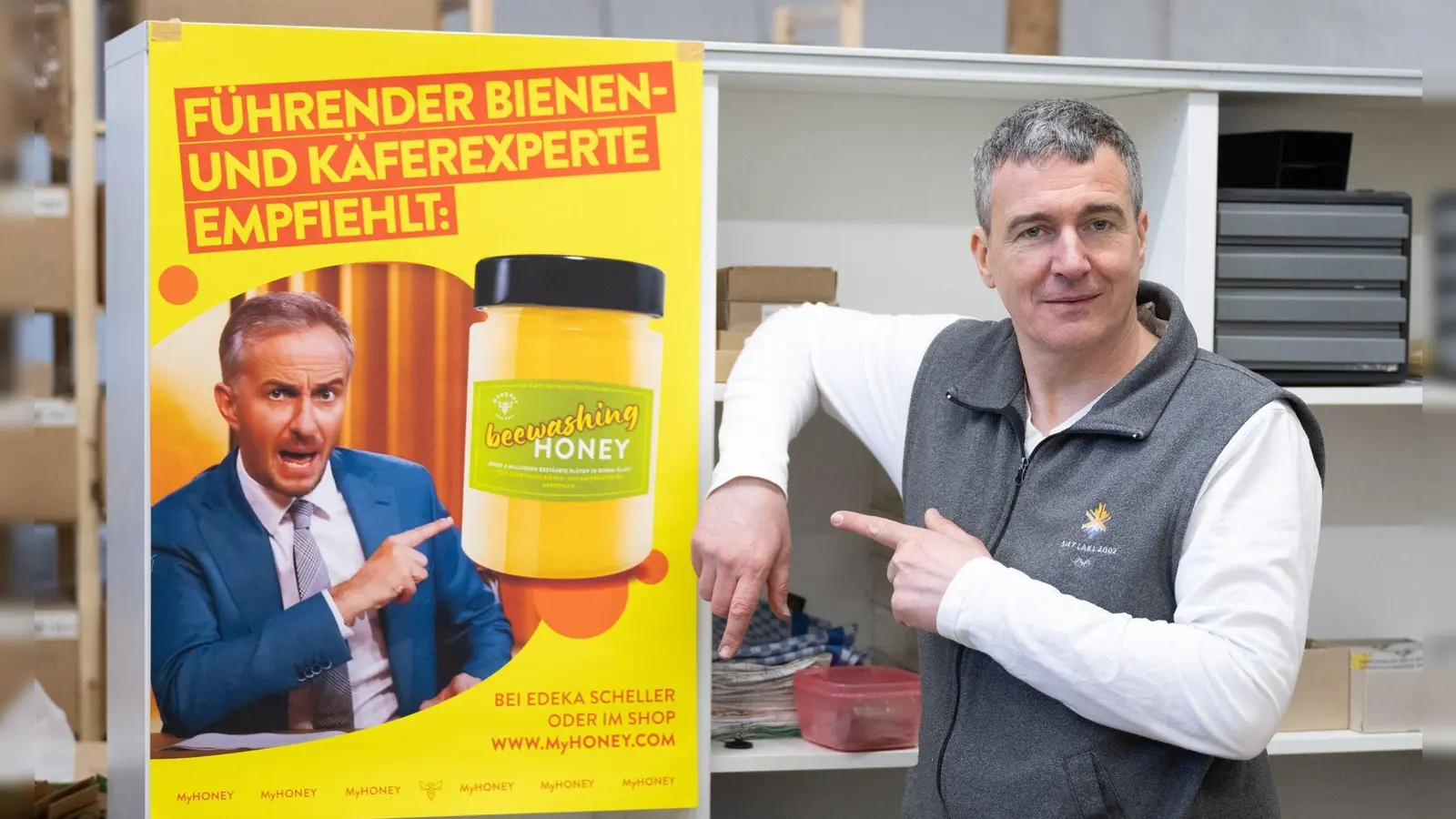 Imker Rico Heinzig neben einem Plakat mit dem Foto des Moderators Jan Böhmermann. (Foto: Sebastian Kahnert/dpa)