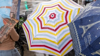Der Regenschirm sollte in vielen Regionen Bayerns in den kommenden Tagen noch dabei sein.  (Foto: Peter Kneffel/dpa)