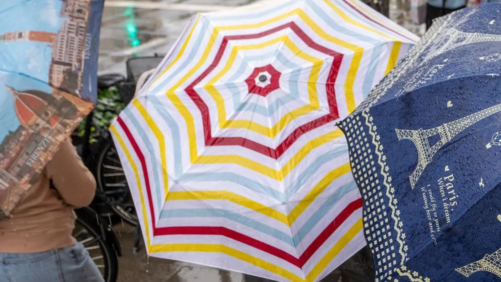 Der Regenschirm sollte in vielen Regionen Bayerns in den kommenden Tagen noch dabei sein.  (Foto: Peter Kneffel/dpa)