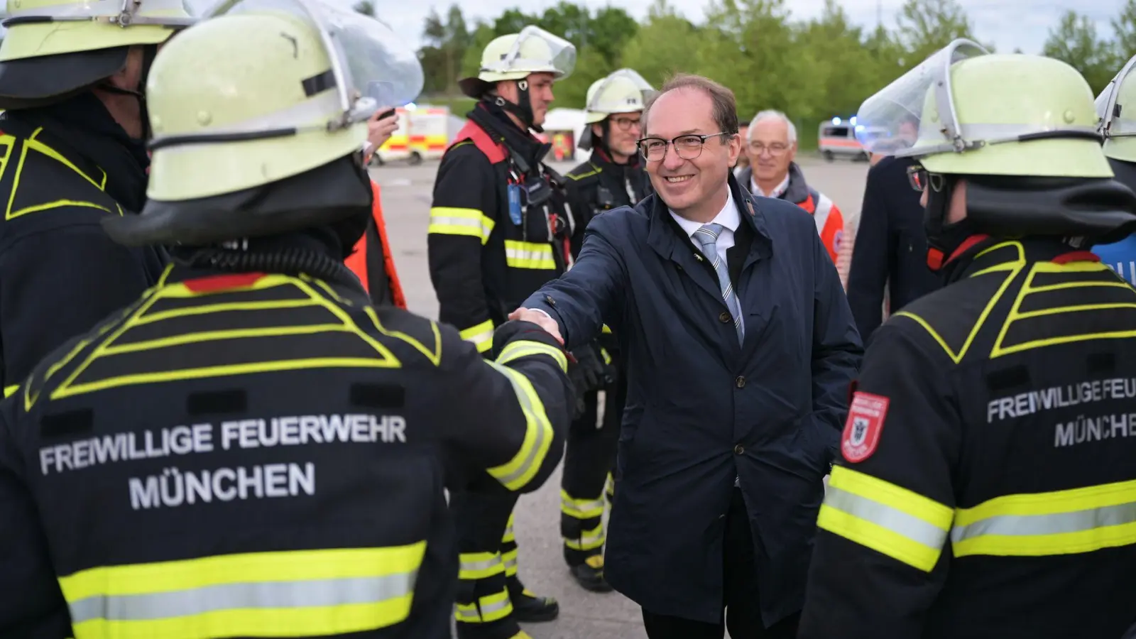 Sie bekommen für die Übung frei: Rettungskräfte der Freiwilligen Feuerwehr werden von Innenminister Dobrindt begrüßt. (Foto: Malin Wunderlich/dpa)