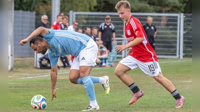 Hagenbüchachs Spielertrainer Mehmet Karanfil (in Blau) kommt im Zweikampf mit dem Laubendorfer Leon Horn glatt ins Straucheln. (Foto: Markus Zahn)