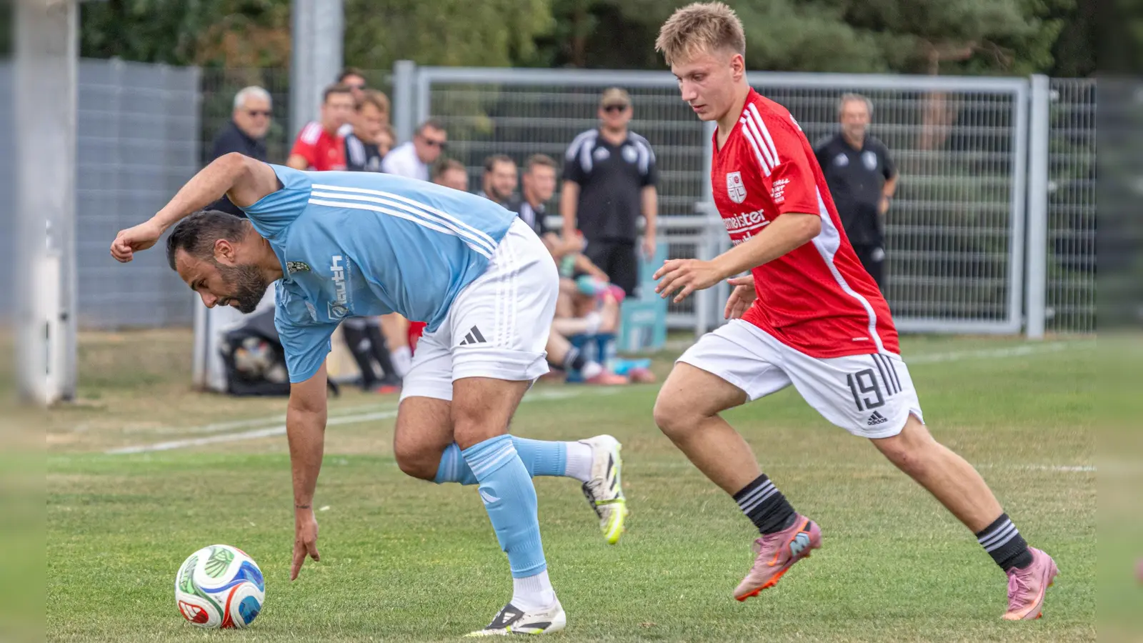 Hagenbüchachs Spielertrainer Mehmet Karanfil (in Blau) kommt im Zweikampf mit dem Laubendorfer Leon Horn glatt ins Straucheln. (Foto: Markus Zahn)