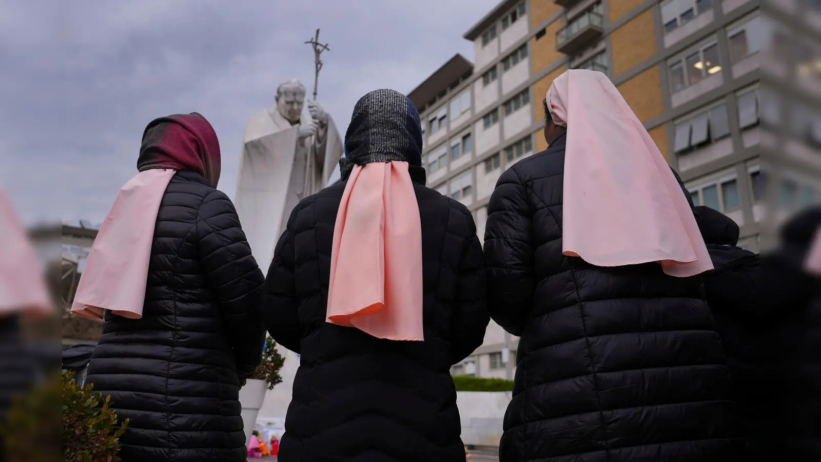 Papst Franziskus liegt seit mehr als zwei Wochen im Gemelli-Krankenhaus, wo vor einem Denkmal von Johannes Paul II. Nonnen für ihn beten. (Foto: Kirsty Wigglesworth/AP/dpa)