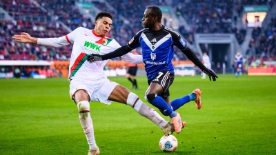 Augsburgs Noahkai Banks im Zweikampf mit Jean-Luc Dompé vom HSV. (Foto: Tom Weller/dpa)