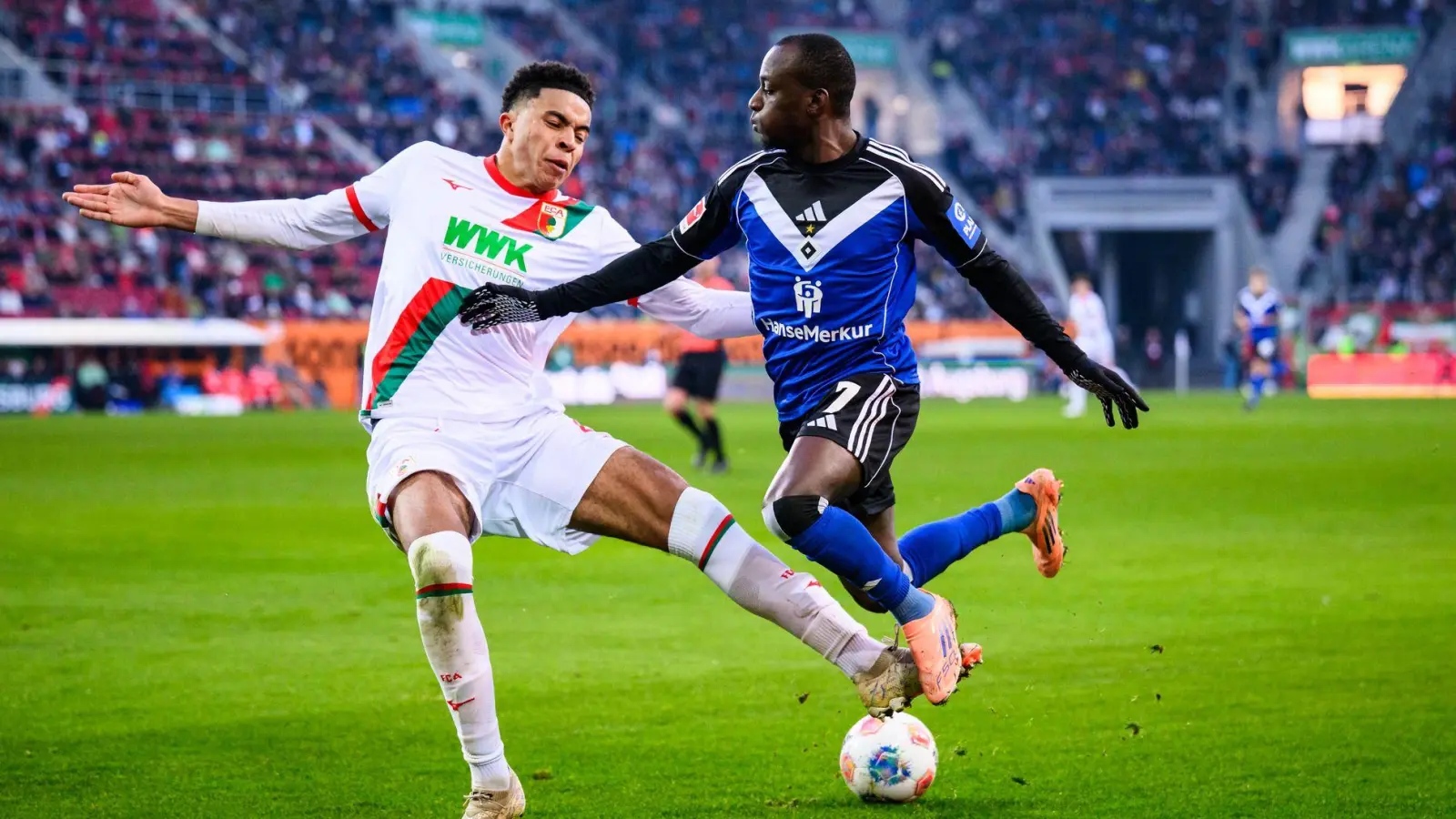 Augsburgs Noahkai Banks im Zweikampf mit Jean-Luc Dompé vom HSV. (Foto: Tom Weller/dpa)